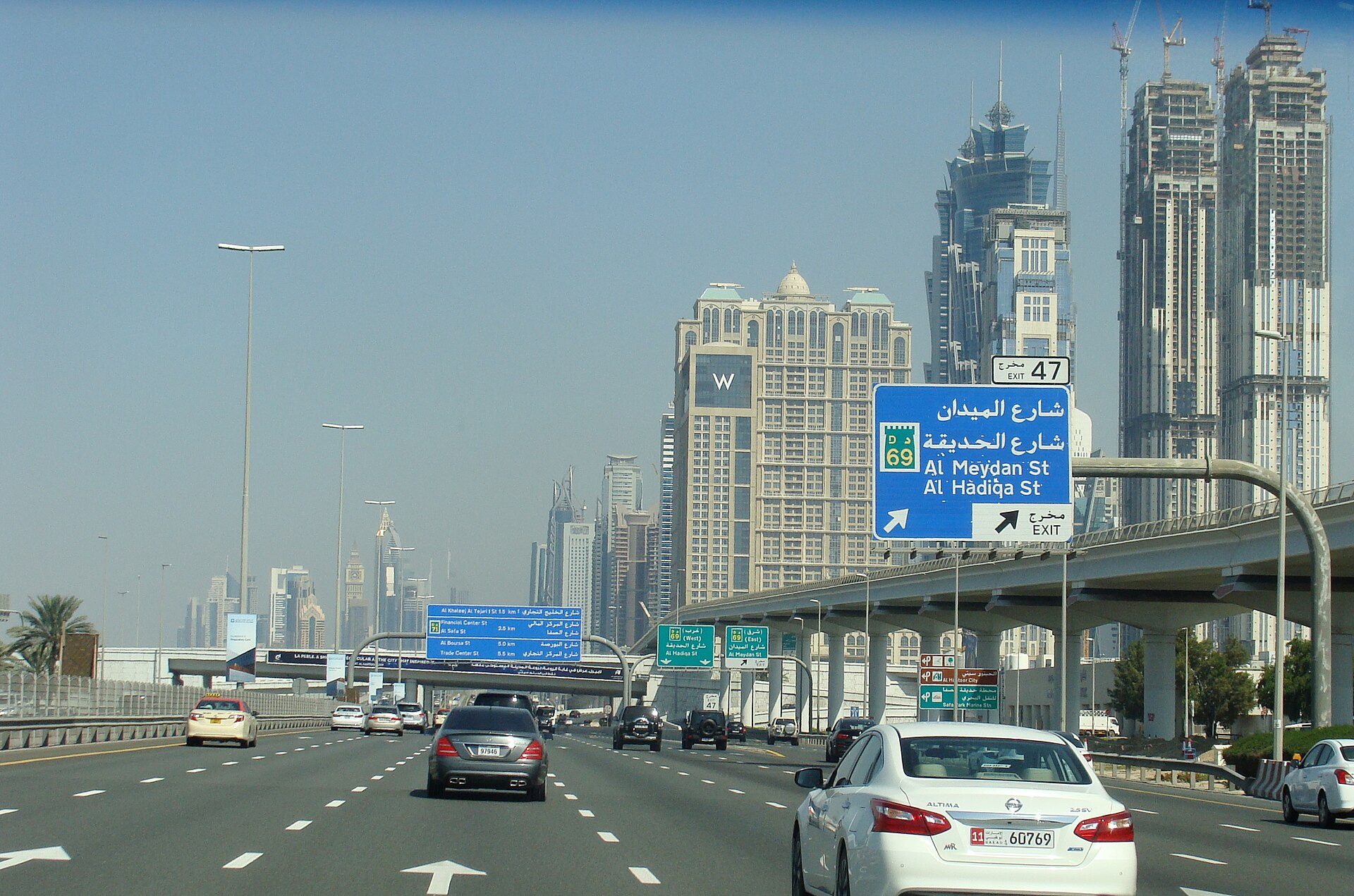 Highway approach toward Abu Dhabi with desert horizon and emerging towers